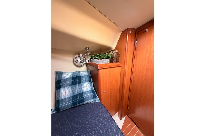 Slide: The Image of Cozy cabin interior of 2009 Hunter 33 sailboat with plaid pillow and wooden cabinetry. - 57
