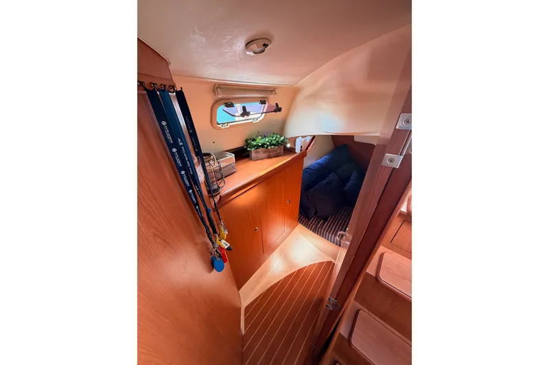 Slide: The Image of Interior of 2009 Hunter 33 sailboat cabin with wood finish and cozy seating area. - 43