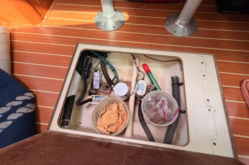 Slide: The Image of Open hatch on 2009 Hunter 33 sailboat floor, revealing storage and maintenance area. - 61