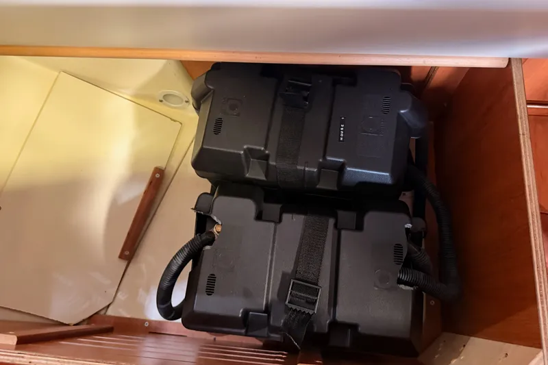 Slide: The Image of Battery compartment in a 2009 Hunter 33 sailboat, featuring secured black battery boxes. - 70