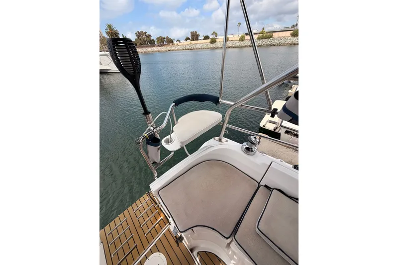 Slide: The Image of 2009 Hunter 33 sailboat cockpit with seating, steering wheel, and water view. - 27
