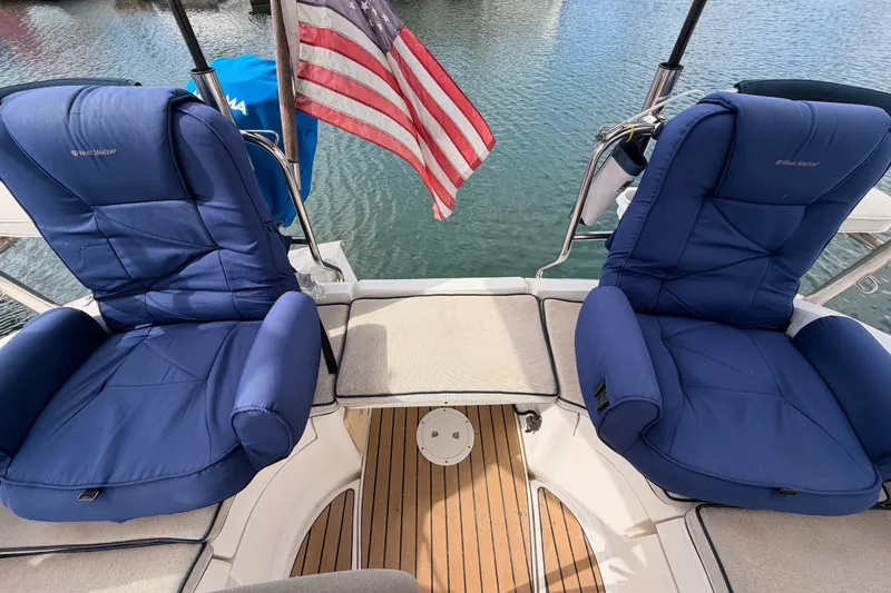 Slide: The Image of Two blue cushioned seats on a 2009 Hunter 33 sailboat deck with American flag. - 24