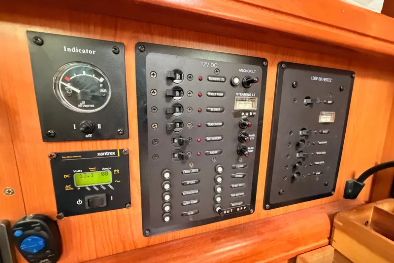 Slide: The Image of Electrical control panel on a 2009 Hunter 33 sailboat, featuring various switches and indicators. - 49