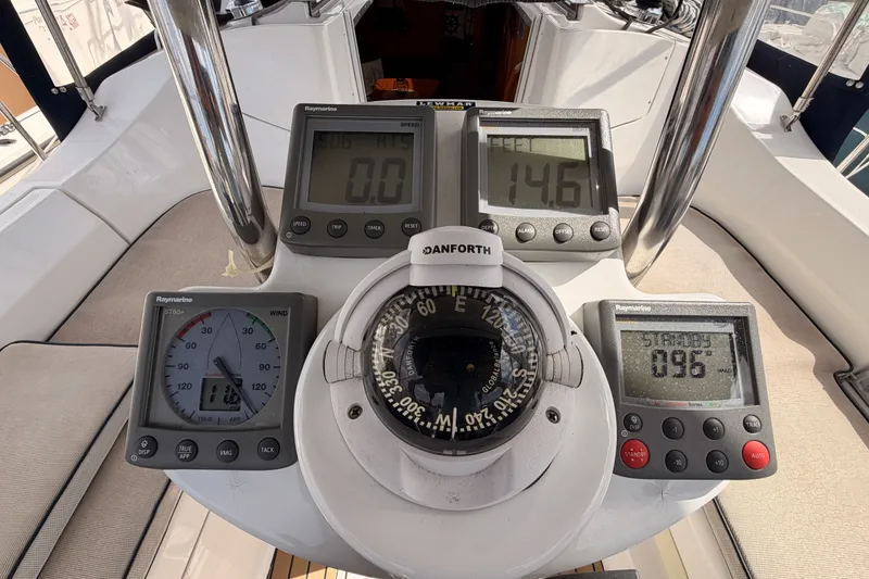 Slide: The Image of Cockpit instruments of a 2009 Hunter 33 sailboat, featuring Raymarine displays and a Danforth compass. - 30