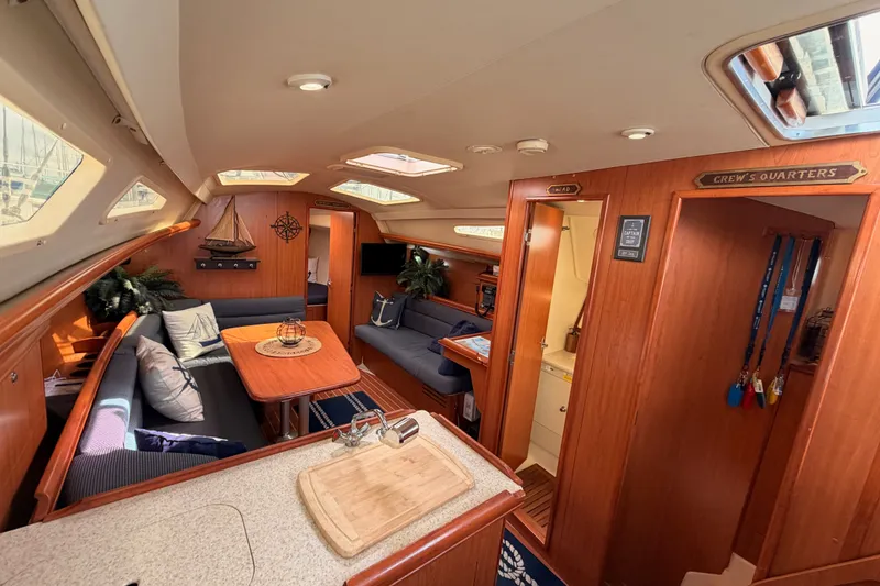 Slide: The Image of Interior of 2009 Hunter 33 sailboat, featuring cozy seating, wooden finishes, and nautical decor. - 41