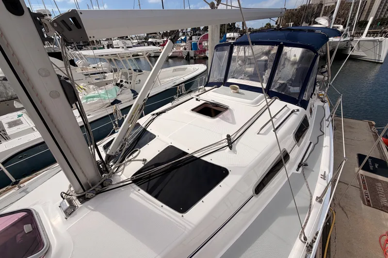 Slide: The Image of 2009 Hunter 33 sailboat docked at marina, featuring sleek design and spacious deck. - 19