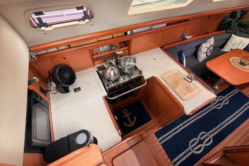 Slide: The Image of Interior of 2009 Hunter 33 sailboat with kitchen and seating area, featuring wood finishes. - 36