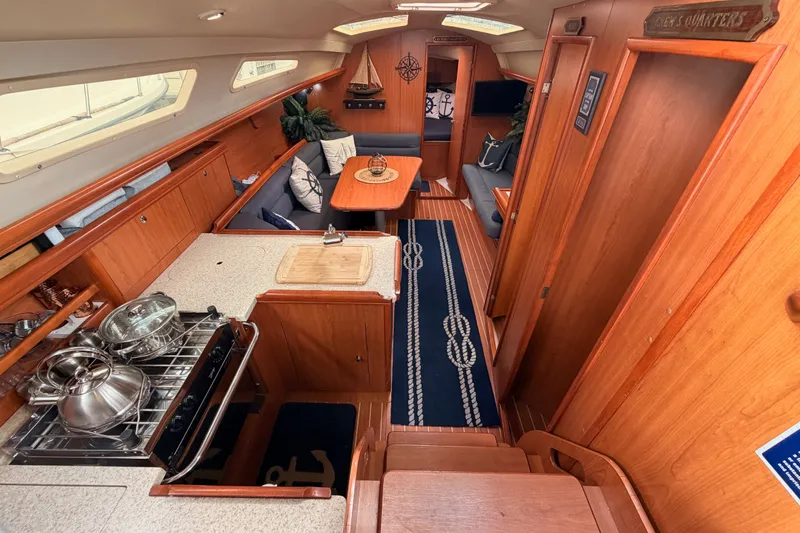 Slide: The Image of Luxurious 2009 Hunter 33 yacht interior with wood finish, kitchen, and seating area. - 35