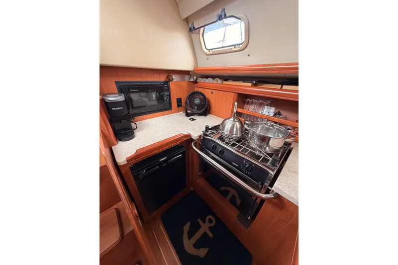 Slide: The Image of Compact kitchen in 2009 Hunter 33 sailboat with stove, microwave, and coffee maker. - 38