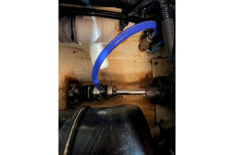 Slide: The Image of Engine compartment of a 2009 Hunter 33 sailboat, featuring hoses and mechanical components. - 65