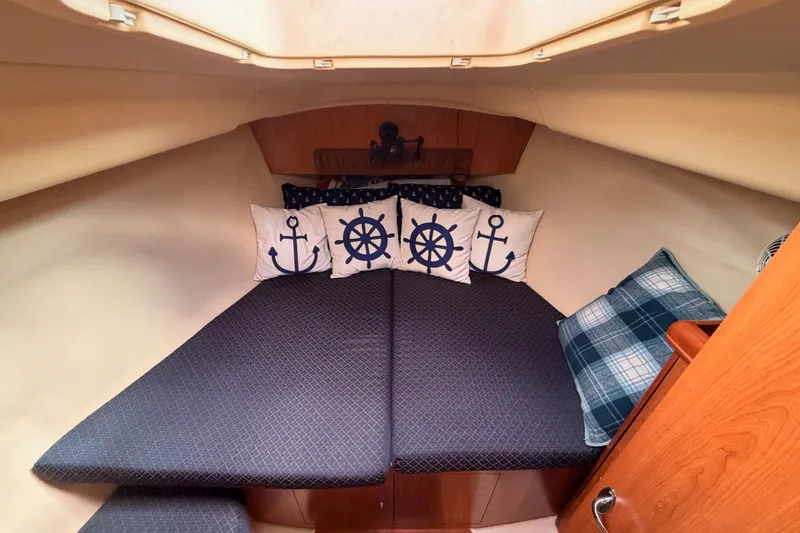 Slide: The Image of Cozy cabin interior of 2009 Hunter 33 sailboat with nautical-themed pillows. - 55