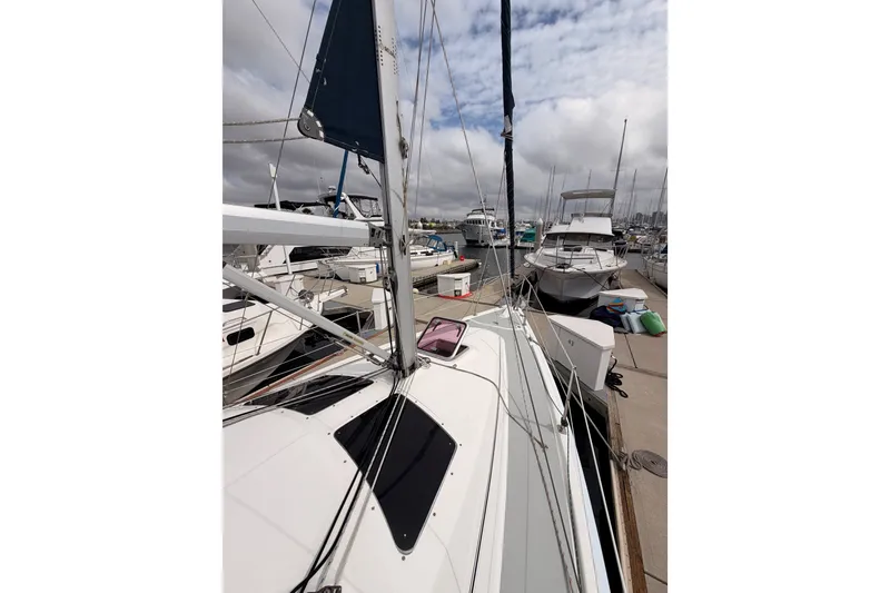 Slide: The Image of 2009 Hunter 33 sailboat docked at marina with other boats under cloudy sky. - 13