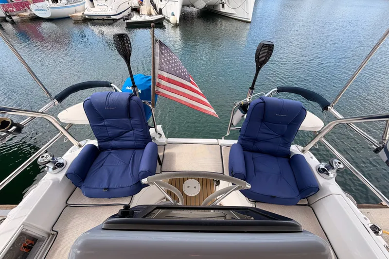 Slide: The Image of 2009 Hunter 33 sailboat cockpit with blue seats and American flag at marina. - 23
