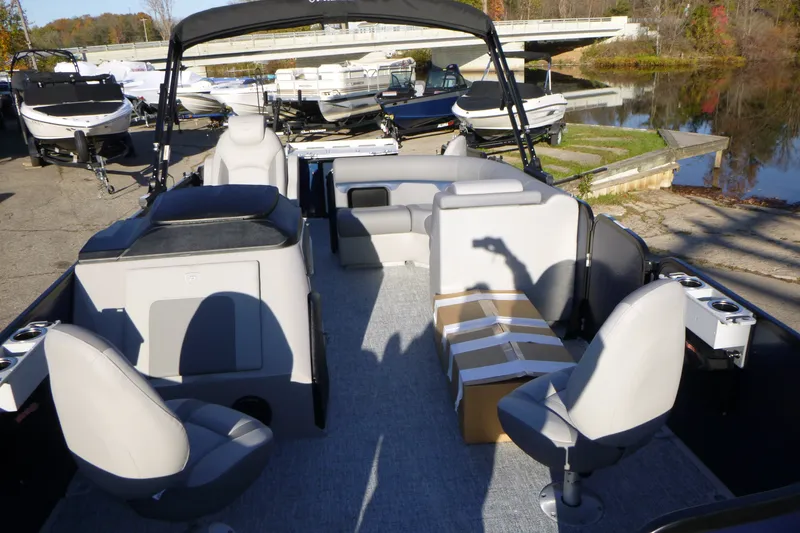 Slide: The Image of 2027 Premier 210 Sunsation Angler 4PT-CL pontoon boat with seating, docked near a serene lake. - 12