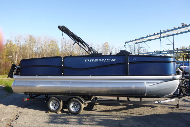 The Image of 2027 Premier 210 Sunsation Angler 4PT pontoon boat on trailer, outdoors. - 0
