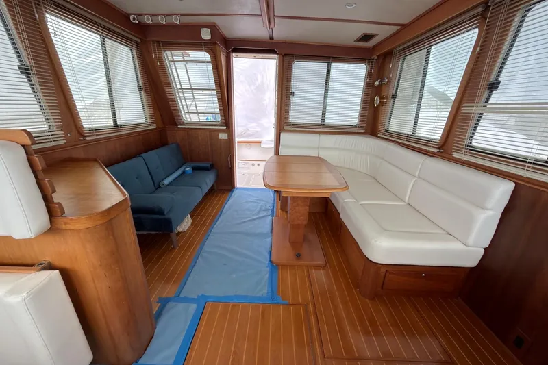 Slide: The Image of Interior of 2004 Sabre 42 Fly Bridge yacht with wood paneling and white seating. - 14