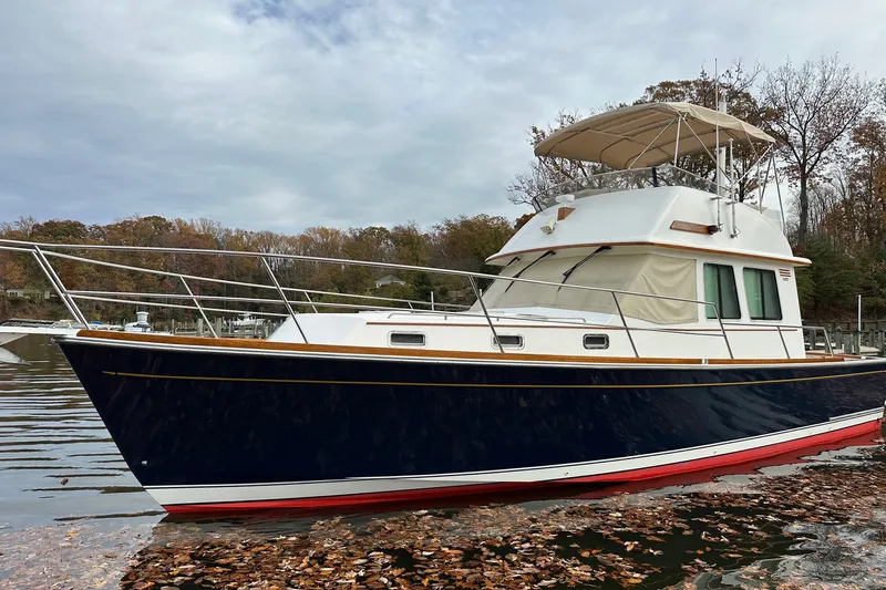 The Image of 2004 Sabre 42 Fly Bridge yacht on calm water, surrounded by autumn foliage. - 0