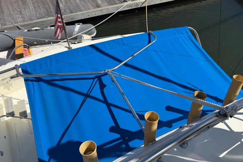 Slide: The Image of 1983 Bertram 38III Convertible boat with blue canopy and fishing rod holders. - 42
