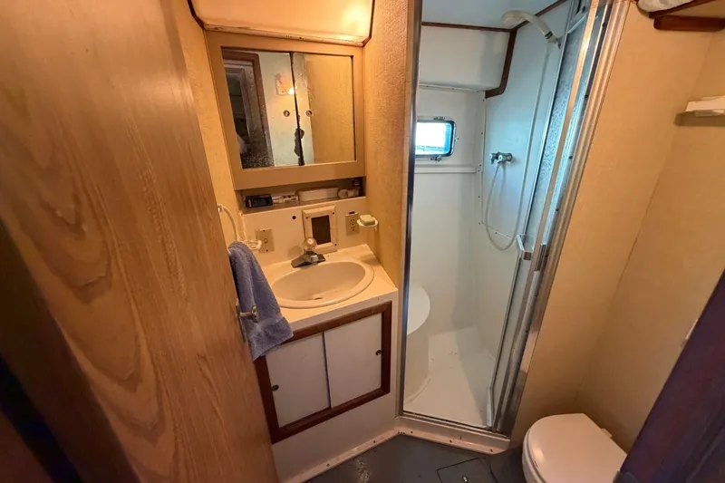 Slide: The Image of Compact bathroom in a 1983 Bertram 38III Convertible yacht with shower and sink. - 18