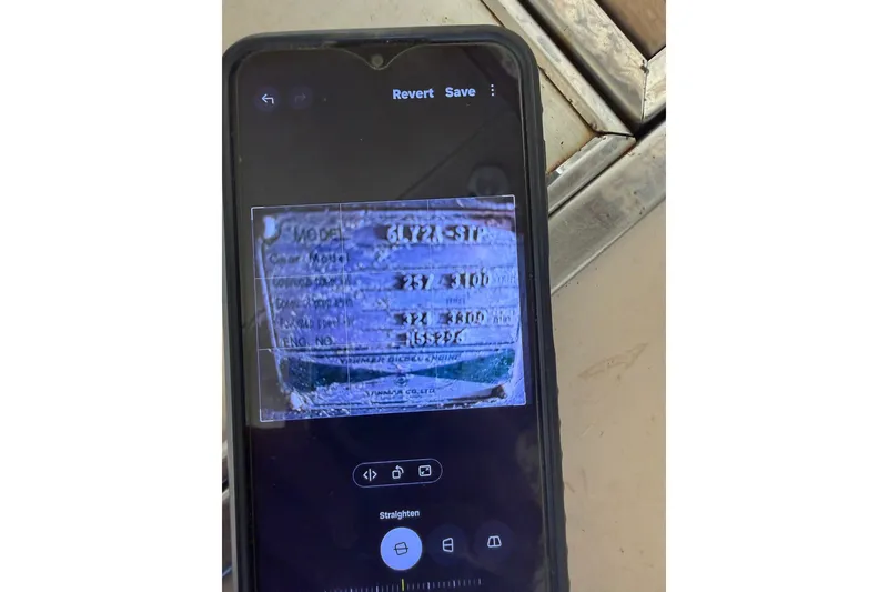 Slide: The Image of Smartphone displaying a blurred image of a Bertram 38III Convertible 1983 model plate. - 27