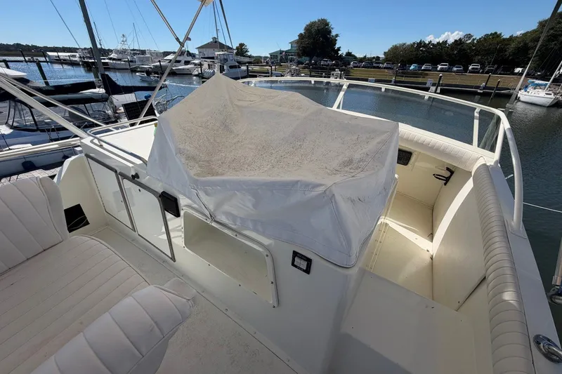 Slide: The Image of 1983 Bertram 38III Convertible yacht cockpit with covered controls, docked at marina. - 31