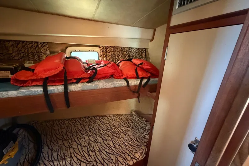 Slide: The Image of Cabin interior of 1983 Bertram 38III Convertible with life jackets on bunk beds. - 23