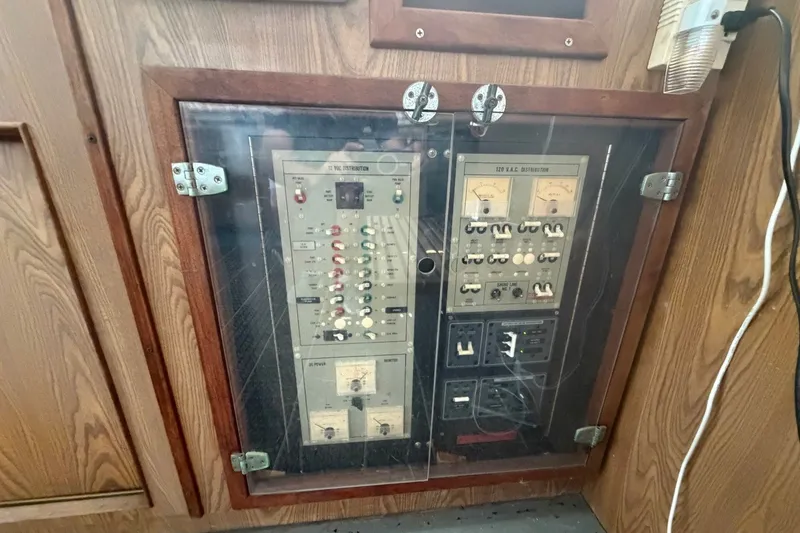 Slide: The Image of Electrical panel on a 1983 Bertram 38III Convertible boat, enclosed in a wooden cabinet. - 14
