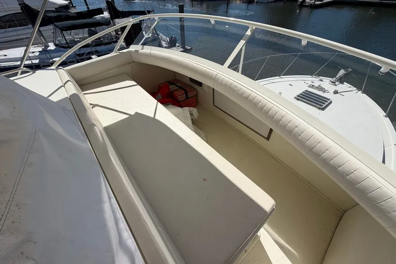 Slide: The Image of 1983 Bertram 38III Convertible yacht interior with cushioned seating and marina view. - 32