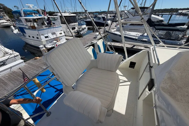 Slide: The Image of 1983 Bertram 38III Convertible yacht interior with white seating at marina. - 29