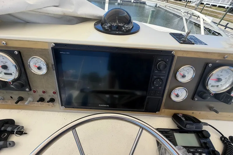 Slide: The Image of Control panel of a 1983 Bertram 38III Convertible boat with gauges and Garmin GPS. - 35