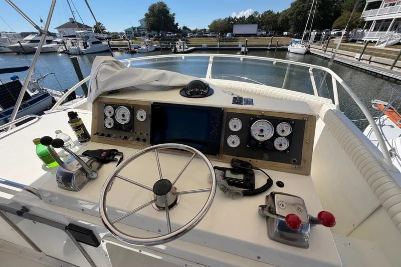 Slide: The Image of Helm of 1983 Bertram 38III Convertible yacht with gauges and controls at marina. - 33