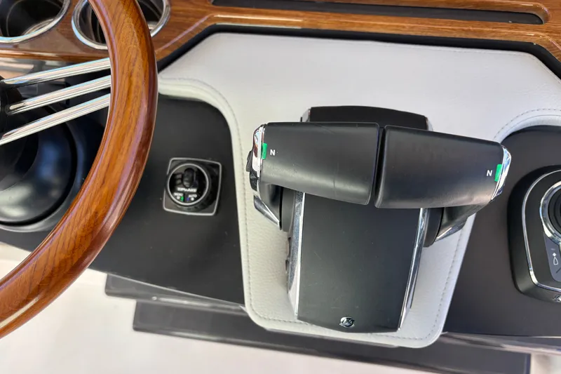 Slide: The Image of 2026 Tiara Yachts 34 LS helm with wooden steering wheel and throttle controls. - 32