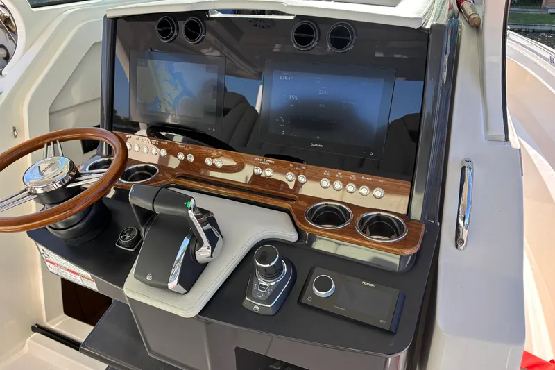 Slide: The Image of 2026 Tiara Yachts 34 LS helm with dual screens, wooden accents, and modern controls. - 30