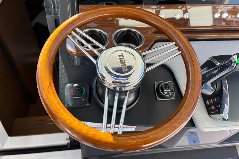 Slide: The Image of Steering wheel of 2026 Tiara Yachts 34 LS, featuring wood and chrome accents. - 36