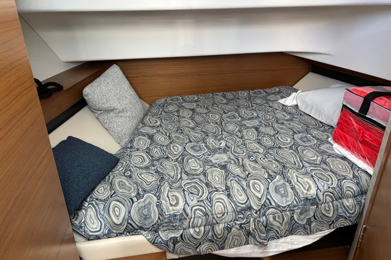 Slide: The Image of Cozy cabin interior of 2026 Tiara Yachts 34 LS with patterned bedding and pillows. - 33