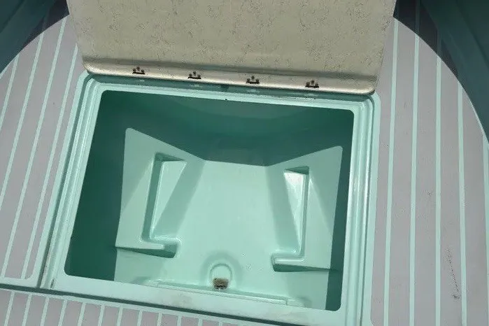 Slide: The Image of An open storage compartment on a boat with light blue interior lining. - 32