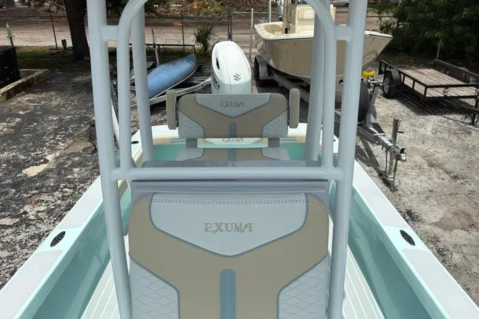 Slide: The Image of 2024 Exuma 22 boat interior with custom seating and white frame, parked outdoors. - 24