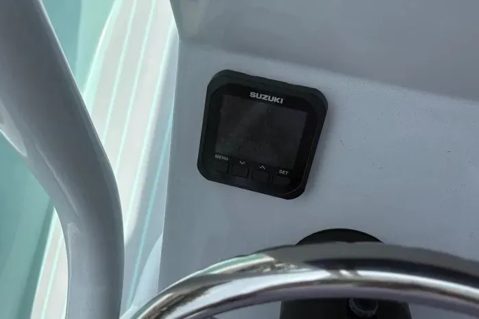 Slide: The Image of Dashboard of 2024 Exuma 22 boat with Suzuki display and steering wheel. - 19