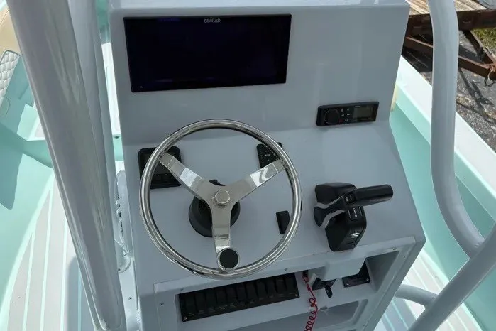 Slide: The Image of 2024 Exuma 22 boat dashboard with steering wheel, controls, and display screen. - 16