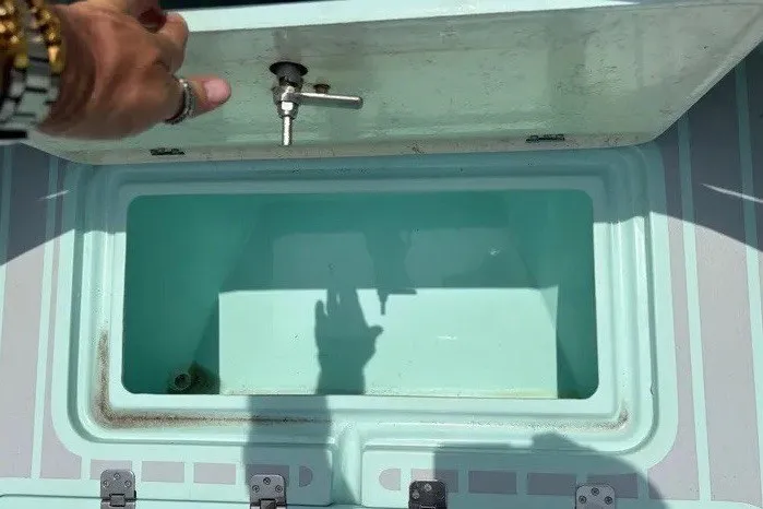 Slide: The Image of An open storage compartment on a boat with a faucet above. - 35