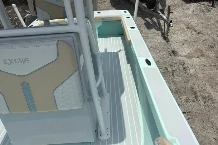 Slide: The Image of 2024 Exuma 22 boat interior with light blue and beige seating, docked on land. - 27