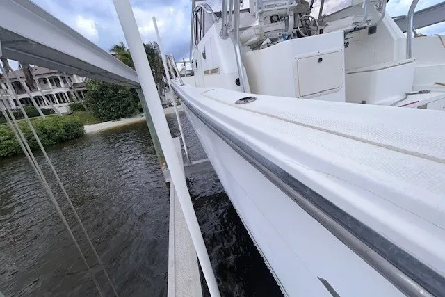 Slide: The Image of 2000 Shamrock 290 Walkaround boat docked near waterfront homes. - 8