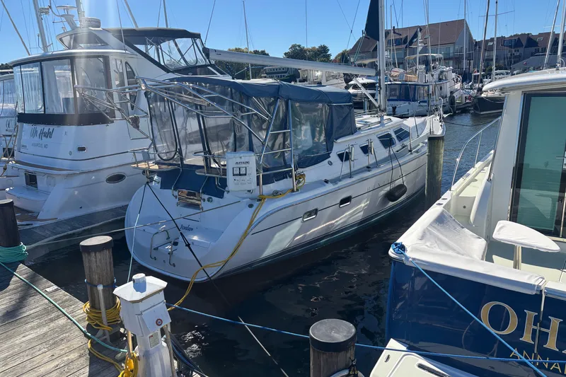 Slide: The Image of 2008 Hunter 41 Deck Salon sailboat docked at marina, surrounded by other boats. - 2