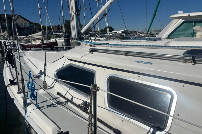 Slide: The Image of 2008 Hunter 41 Deck Salon sailboat docked at marina, showcasing sleek design and windows. - 10