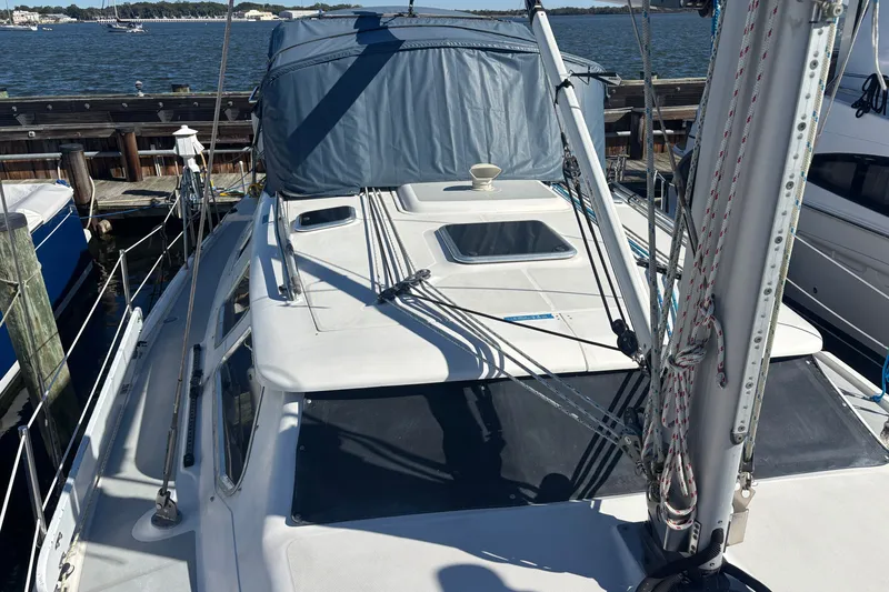 Slide: The Image of 2008 Hunter 41 Deck Salon sailboat docked, featuring a covered cockpit and visible rigging. - 31