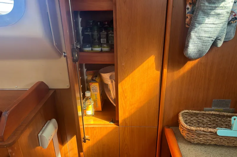 Slide: The Image of Interior of 2008 Hunter 41 Deck Salon with wooden cabinetry and storage shelves. - 12