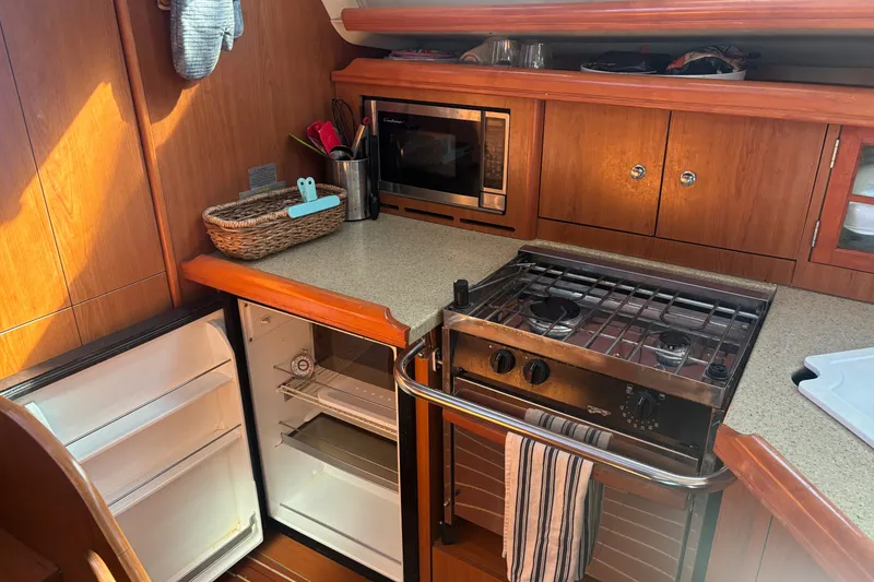 Slide: The Image of 2008 Hunter 41 Deck Salon kitchen with stove, fridge, and microwave. - 11