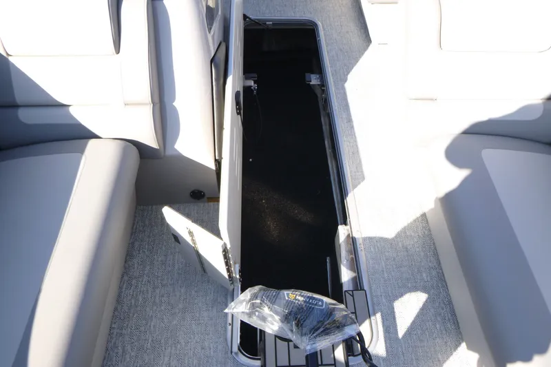 Slide: The Image of Open storage compartment on 2027 Premier 230 Sunsation Angler 2PT boat, featuring gray seating. - 23