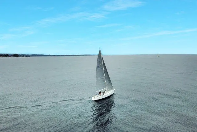 Slide: The Image of Sailboat J/100 by J Boats (2005) cruising on open sea under clear blue sky. - 35