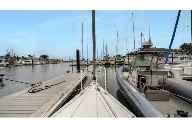 Slide: The Image of Sailboat docked in marina, surrounded by other boats, clear sky. J Boats J/100, 2005 model. - 29